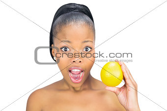 Surprised woman holding orange
