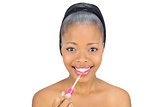 Portrait of smiling woman using lipgloss