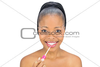 Portrait of smiling woman using lipgloss