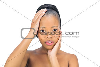 Woman holding hand on head and face