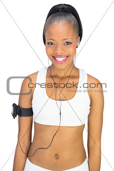 Cheerful attractive woman in sportswear listening to music
