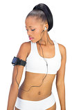 Woman in sportswear looking at her music player