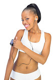 Smiling woman in sportswear using music player while looking at camera