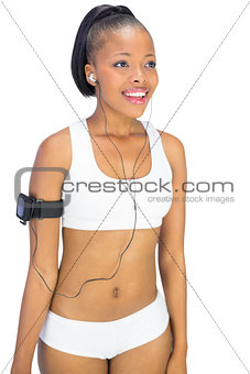 Fit woman in sportswear listening to music