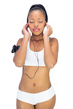 Peaceful woman in sportswear listening to music