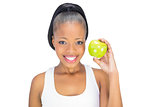 Attractive woman in sportswear holding green apple