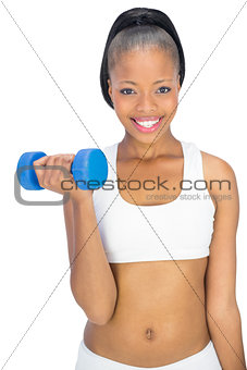 Happy fit woman in sportswear working out with dumbbell