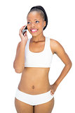 Smiling woman in sportswear talking on phone