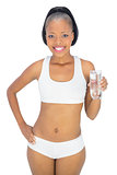 Fit smiling woman holding glass of water