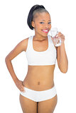 Happy woman in sportswear drinking water