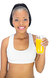 Fit smiling woman holding glass of orange juice