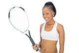 Smiling woman in sportswear holding tennis racket
