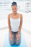 Peaceful woman sitting on blue exercise mat