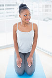 Attractive woman sitting on exercise mat