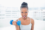 Sporty woman working out with dumbbell