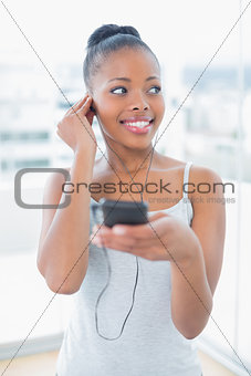 Peaceful woman in sportswear listening to music