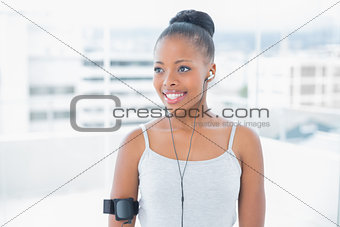 Smiling attractive woman in sportswear listening to music