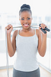 Fit woman in sportswear holding jump rope around her neck
