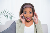 Surprised woman sitting on sofa having a phone call