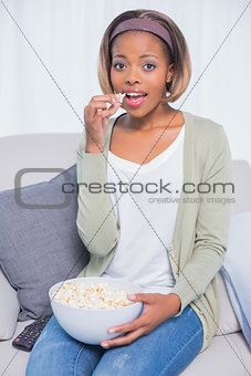 Cheerful attractive woman eating popcorn
