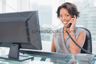 Smiling businesswoman talking on phone while looking at camera