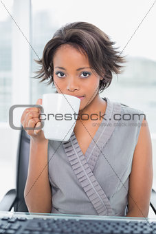 Peaceful businesswoman drinking coffee while having break