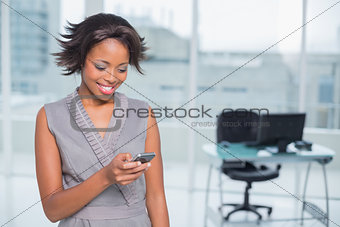 Happy businesswoman standing in her office