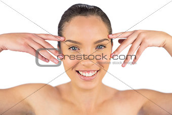Smiling woman touching her face