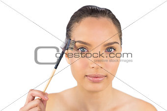 Cheerful woman using eyebrow brush