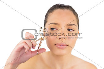 Woman looking at her eyelash curler