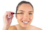 Portrait of young woman applying mascara to her eye