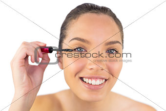 Portrait of young woman applying mascara to her eye