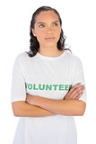 Woman wearing volunteer tshirt with arms crossed while looking upwards