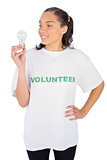Smiling volunteer woman looking at a light bulb