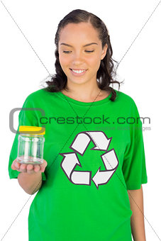Smiling woman wearing green recycling tshirt holding jar