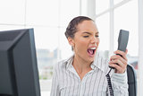 Angry businesswoman screaming at phone