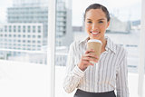 Amused businesswoman holding a coffee