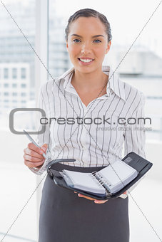 Smiling businesswoman holding her appointment calendar
