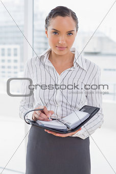 Businesswoman writing in her appointment calendar