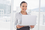 Standing businesswoman using a laptop
