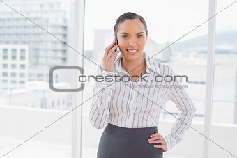 Smiling businesswoman standing and talking on phone