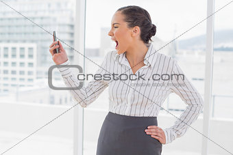 Angry businesswoman screaming at her phone