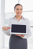 Attractive businesswoman showing laptop screen and pointing at it