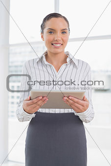 Cheerful businesswoman holding tablet pc