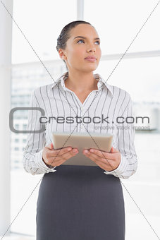 Pensive businesswoman holding a tablet pc