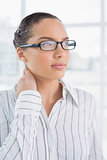 Thoughtful businesswoman with reading glasses standing in office