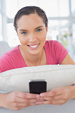 Attractive woman lying on the sofa and texting