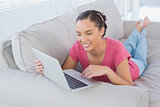 Happy woman using laptop on sofa