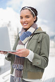 Attractive woman standing outside and holding laptop