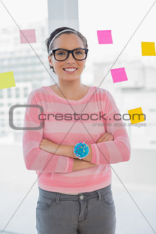 Happy woman with arms crossed in creative office